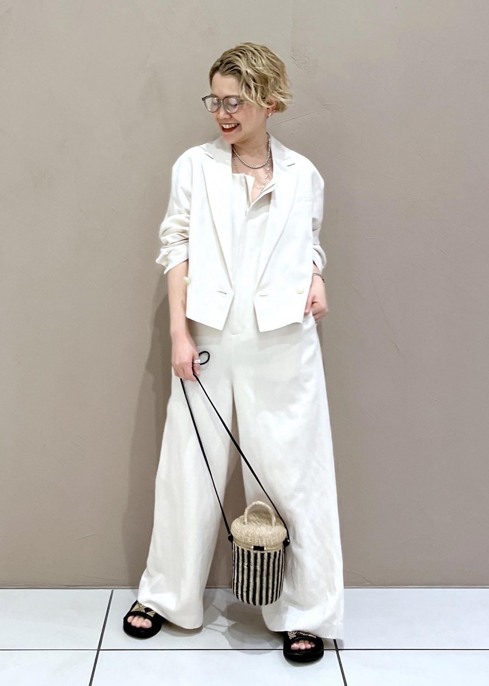 ホワイト系のテーラードジャケット、ホワイト系のつなぎ/オールインワン、ホワイト系のショルダーバッグを着用したレディースの春コーディネートの3枚目の写真
