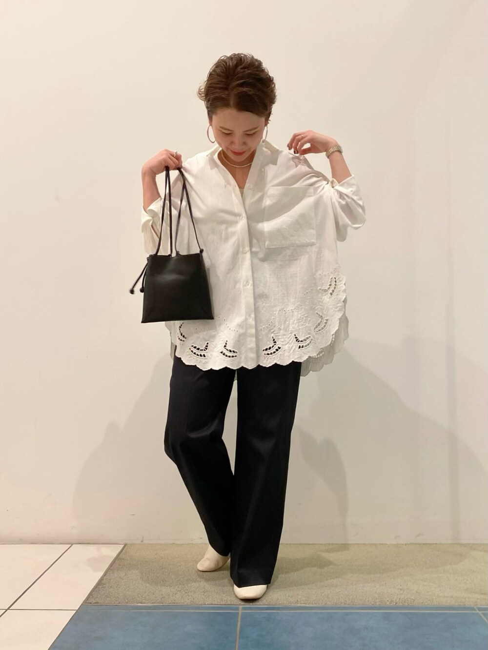 ホワイト系のシャツ/ブラウス、ブラック系のその他パンツ、ブラック系のバッグを着用したレディースの春コーディネートの2枚目の写真