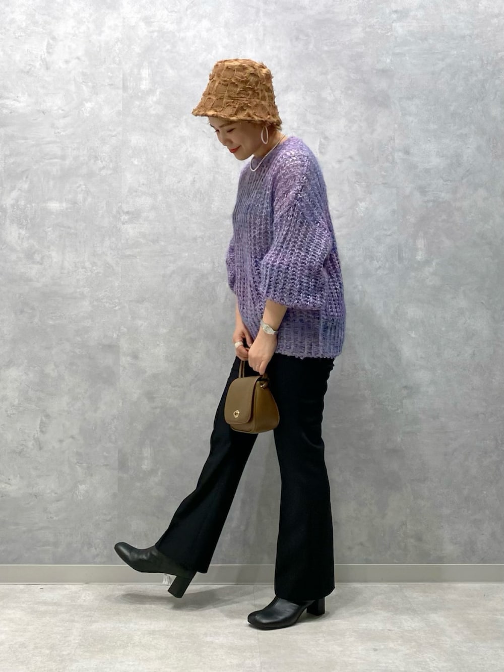 パープル系のニット/セーター、ブラウン系のショルダーバッグ、ブラック系のその他パンツを着用したレディースの秋コーディネートの2枚目の写真
