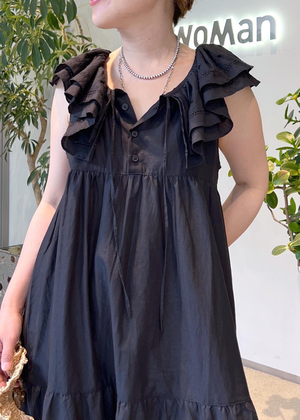 ブラック系のワンピース、ホワイト系のハンドバッグ、ブラック系のサンダルを着用したレディースの夏コーディネートの6枚目の写真