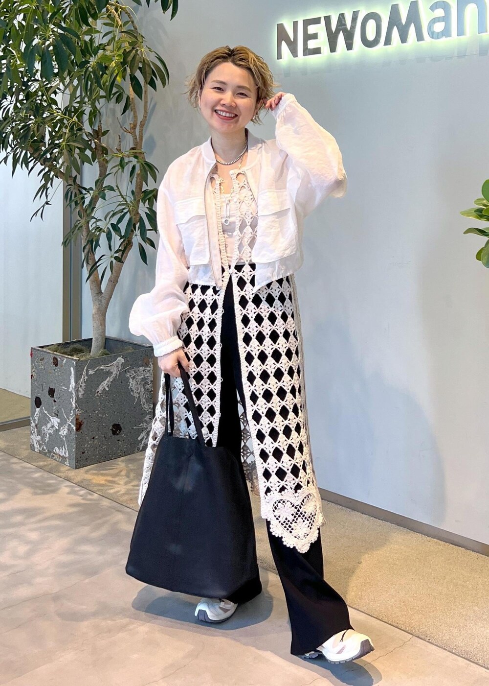 ブラック系のその他パンツ、ホワイト系のワンピース、ホワイト系のブルゾンを着用したレディースの春コーディネートの2枚目の写真