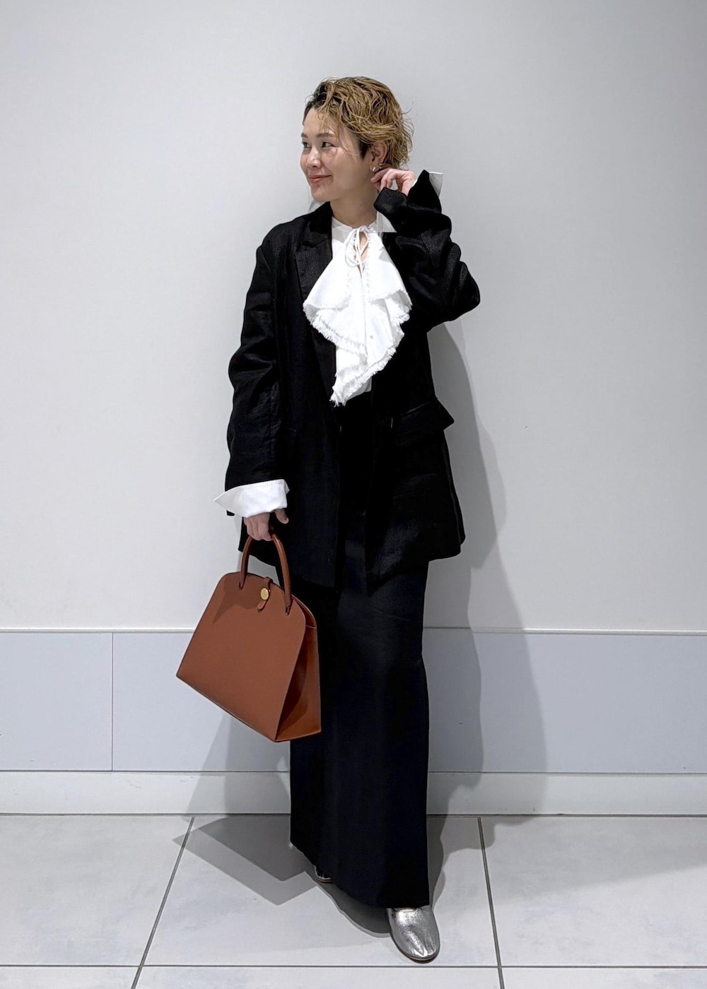 ブラック系のスカート、ブラック系のテーラードジャケット、ホワイト系のシャツ/ブラウスを着用したレディースの冬コーディネートの3枚目の写真