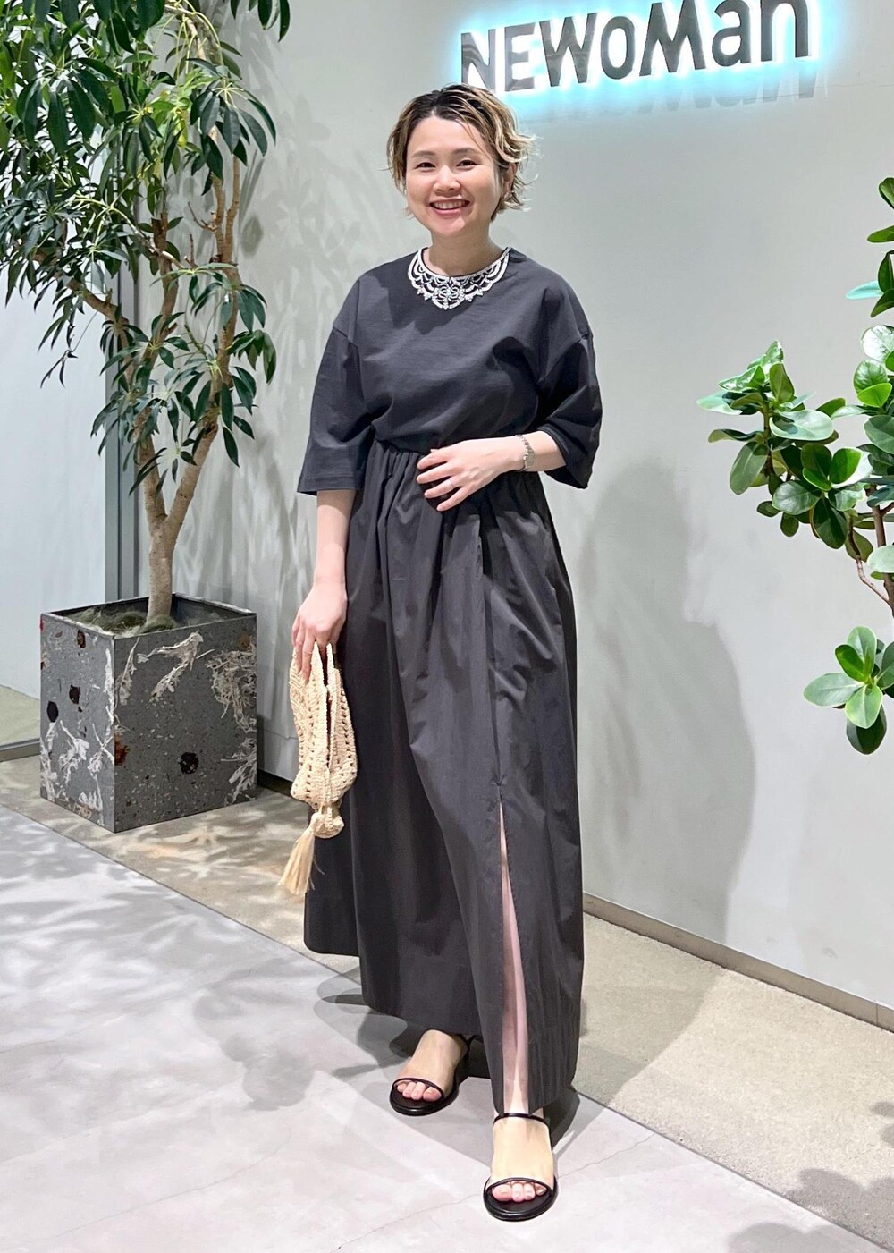 グレー系のスカート、グレー系のTシャツ/カットソー、ホワイト系のサンダルを着用したレディースの春コーディネートの3枚目の写真