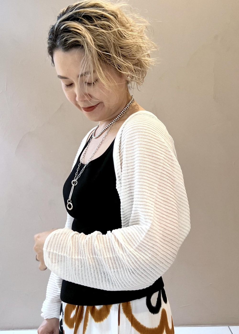 ブラック系のサンダル、ブラック系のタンクトップ、ホワイト系のカーディガン/ボレロを着用したレディースの春コーディネートの6枚目の写真