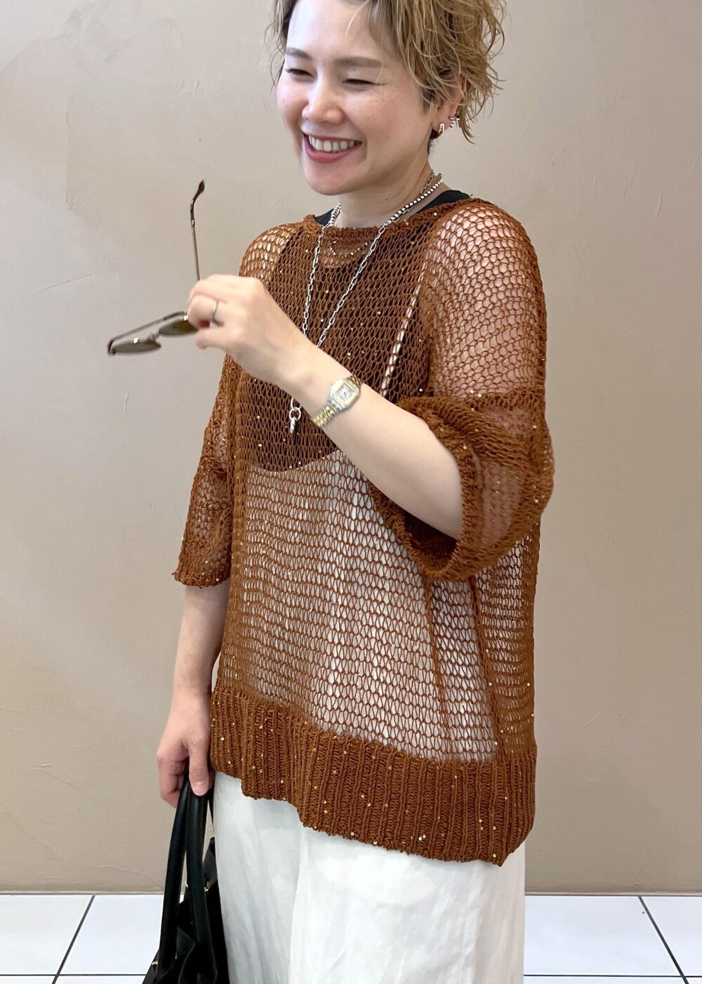 ホワイト系のサロペット/オーバーオール、グレー系のタンクトップ、ブラック系のショルダーバッグを着用したレディースの夏コーディネートの6枚目の写真