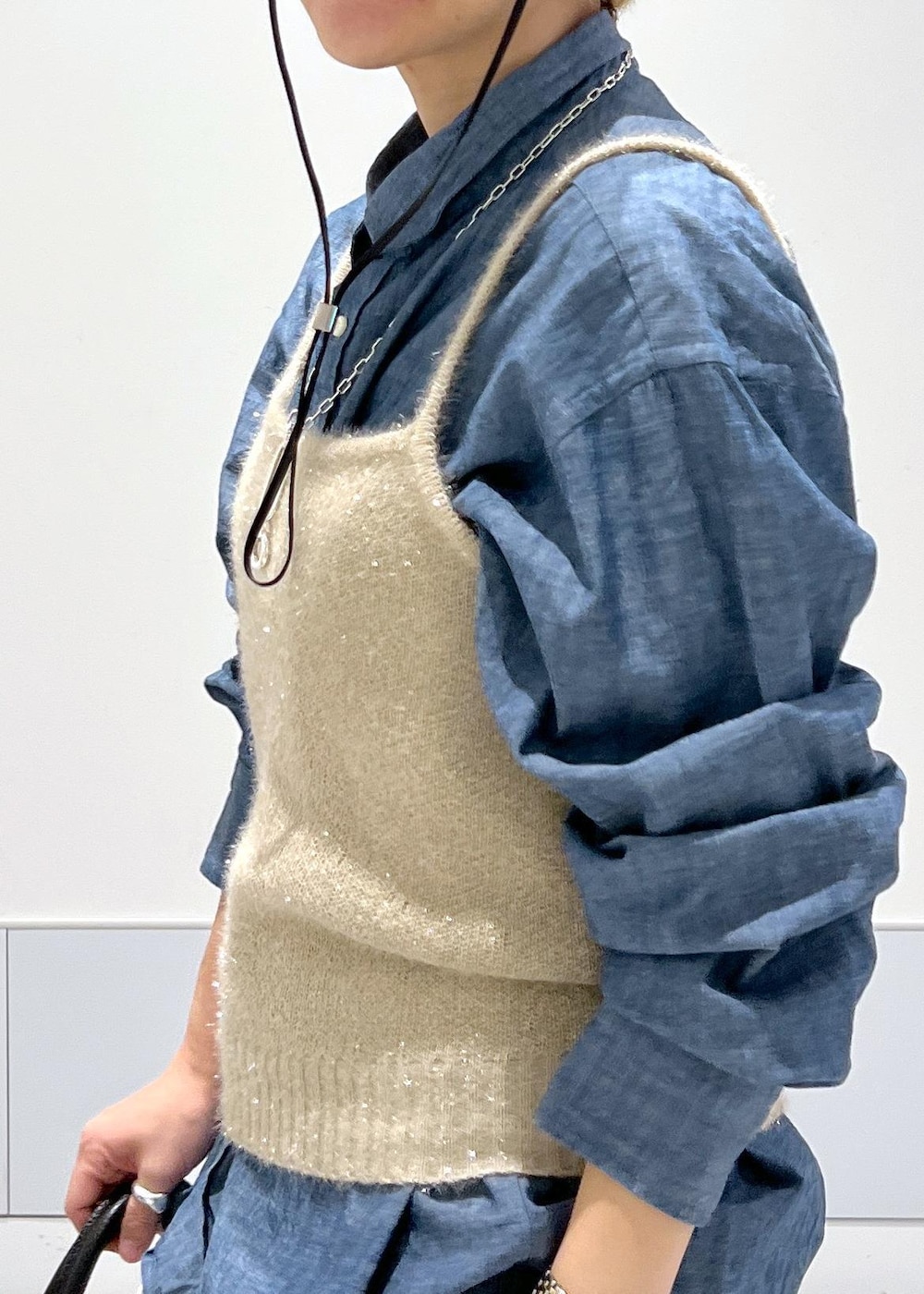 ゴールド系のカーディガン/ボレロ、ブラック系のハンドバッグ、ブラック系のブーツを着用したレディースの秋コーディネートの7枚目の写真