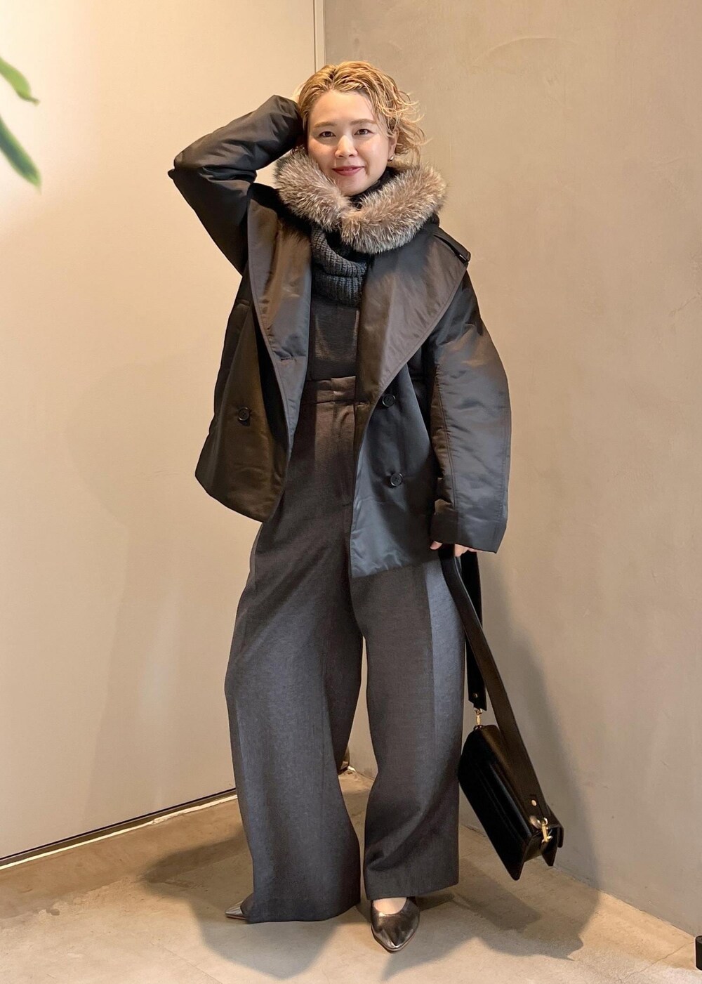 ブラック系のショルダーバッグ、グレー系のニット/セーター、グレー系のスラックスを着用したレディースの秋コーディネートの2枚目の写真