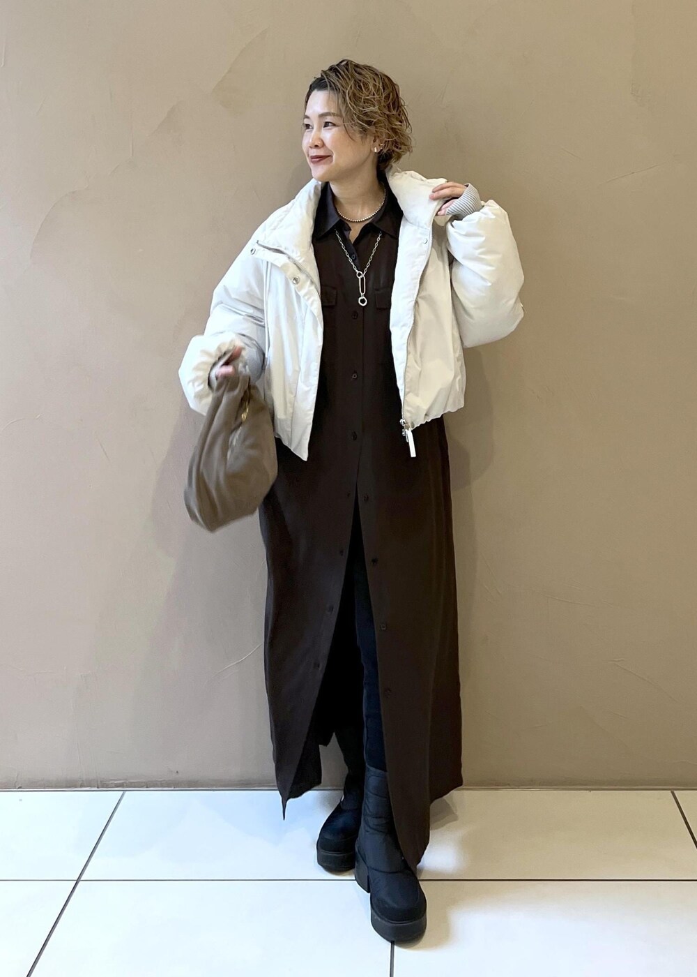 ホワイト系のダウンジャケット/コート、グレー系のハンドバッグ、グレー系のワンピースを着用したレディースの秋コーディネートの4枚目の写真