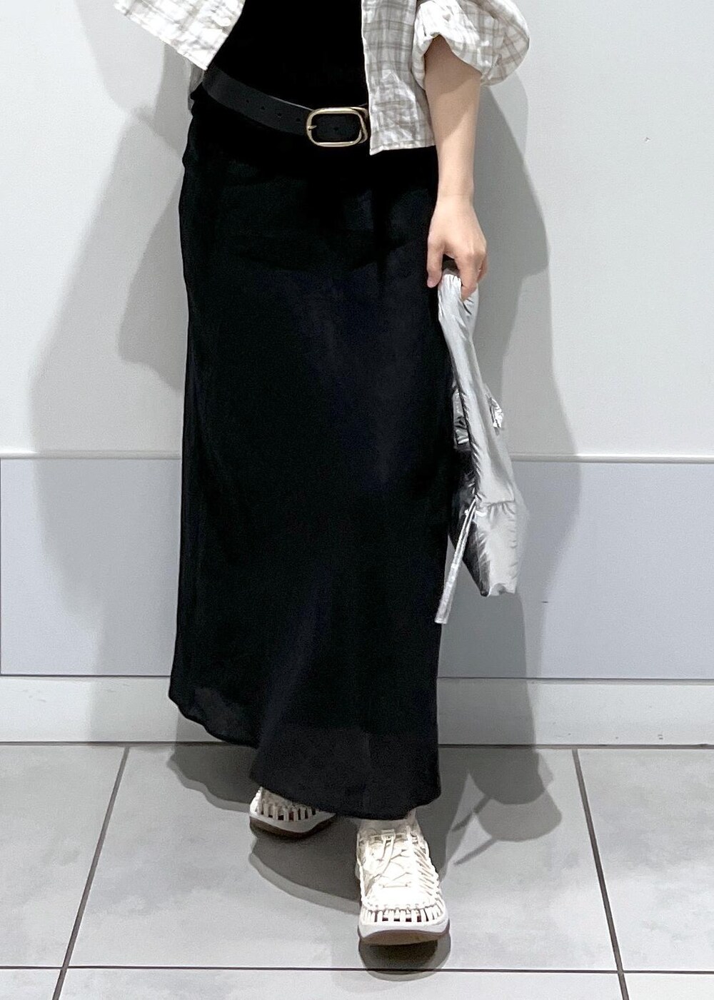 シルバー系のハンドバッグ、ホワイト系のサンダル、ブラック系のスカートを着用したレディースの春コーディネートの8枚目の写真