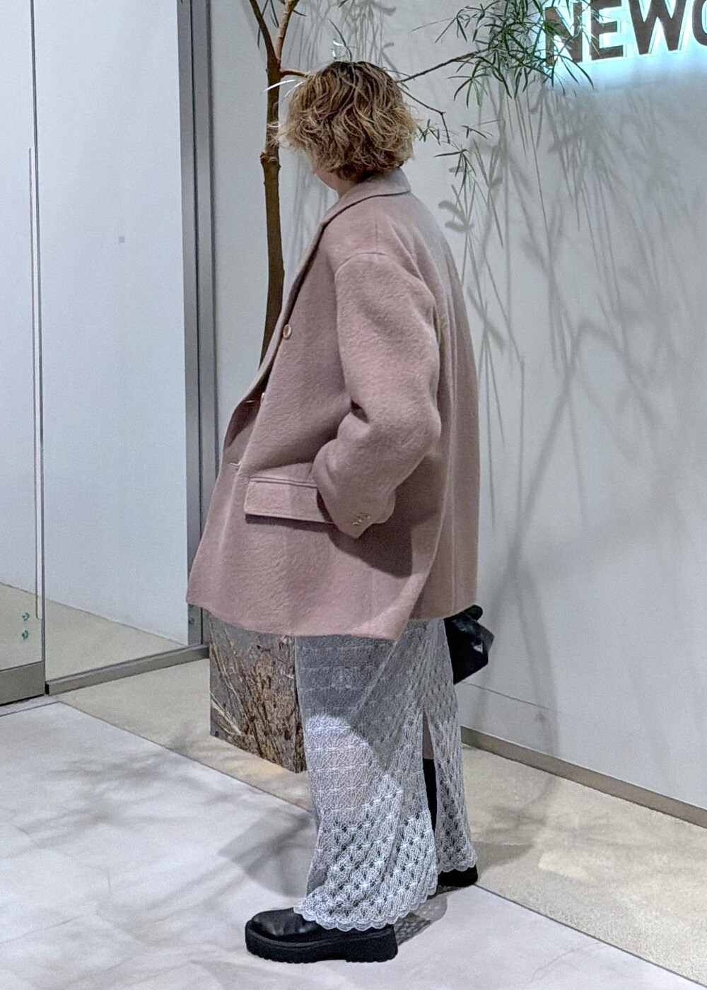 ブラック系のショルダーバッグ、グリーン系のスカート、ブラウン系のチェスターコートを着用したレディースの秋コーディネートの5枚目の写真