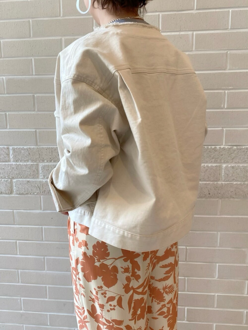 ホワイト系のブルゾン、グレー系のTシャツ/カットソー、オレンジ系のその他パンツを着用したレディースの春コーディネートの3枚目の写真