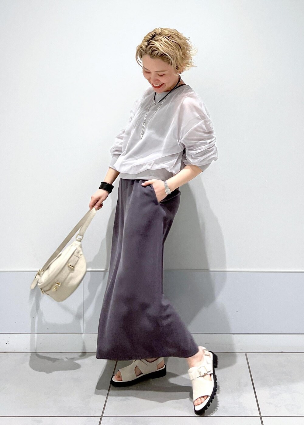 ホワイト系のサンダル、ベージュ系のボディバッグ/ウエストポーチ、グレー系のワンピースを着用したレディースの春コーディネートの3枚目の写真