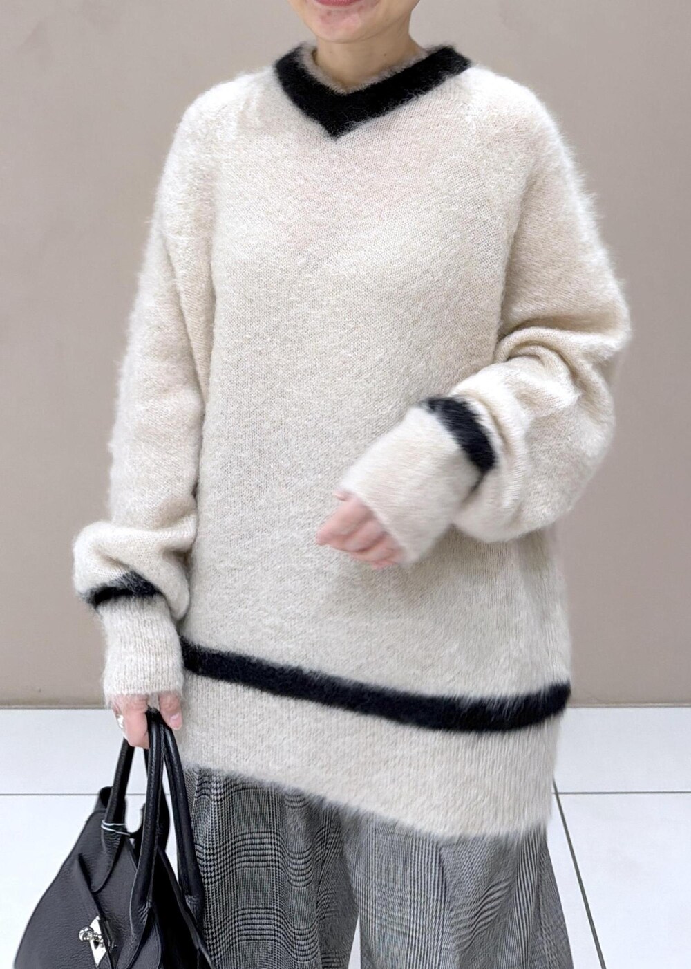 グレー系のスラックス、ブラック系のブーツを着用したレディースの冬コーディネートの7枚目の写真