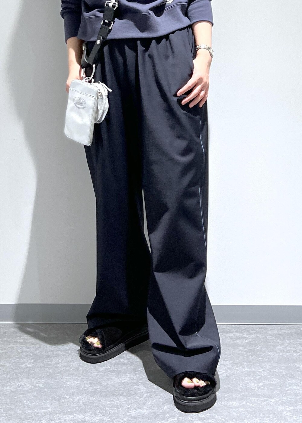 ブルー系のスラックス、グレー系のパーカー、シルバー系のトートバッグを着用したレディースの夏コーディネートの6枚目の写真