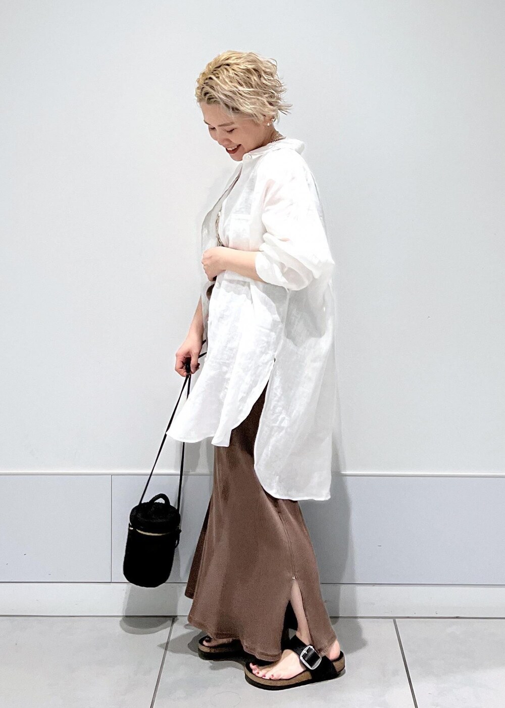 ブラック系のショルダーバッグ、ベージュ系のキャミソール、ブラウン系のタンクトップを着用したレディースの夏コーディネートの9枚目の写真