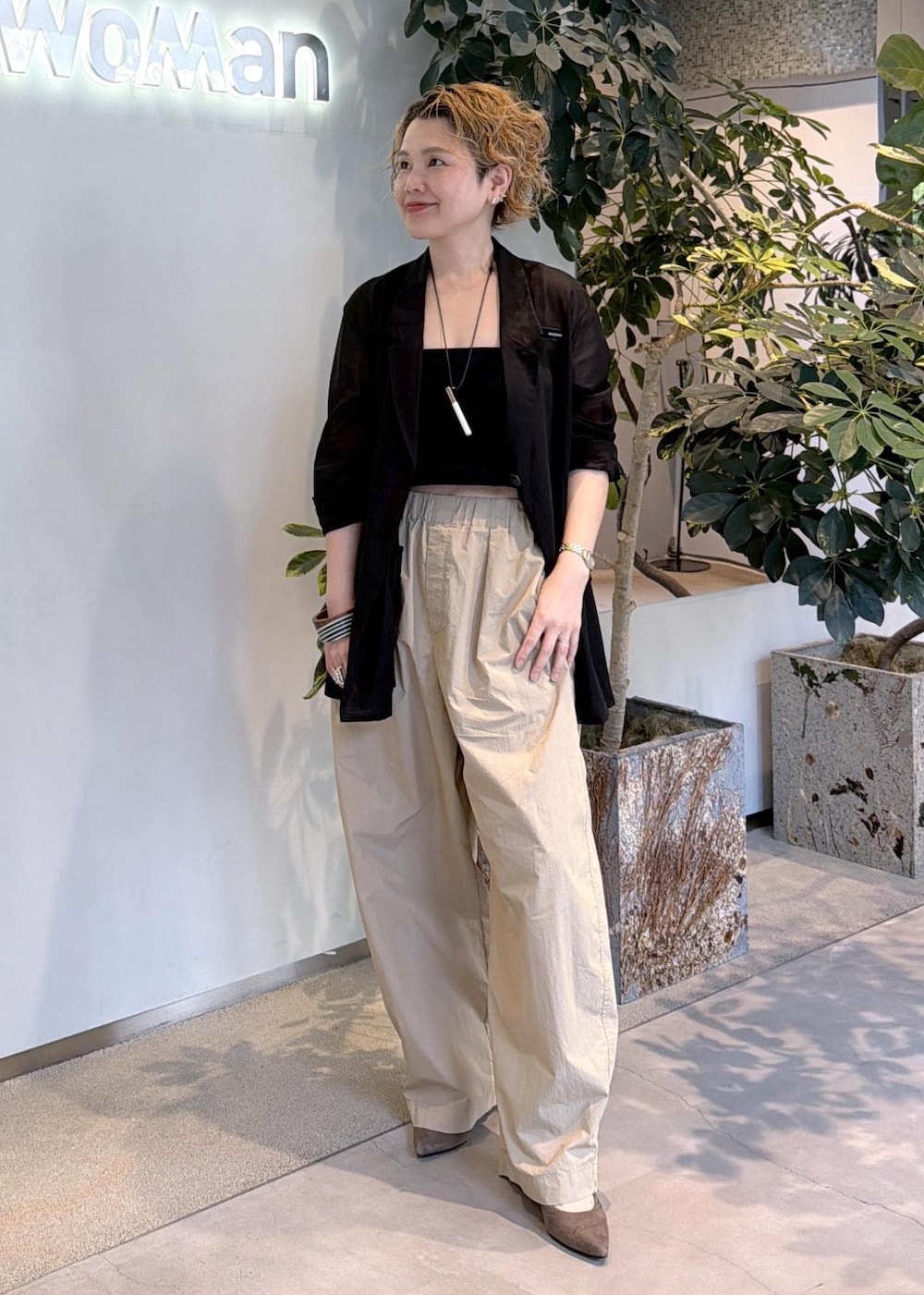 ベージュ系のその他パンツ、ブラック系のテーラードジャケットを着用したレディースの春コーディネートの3枚目の写真