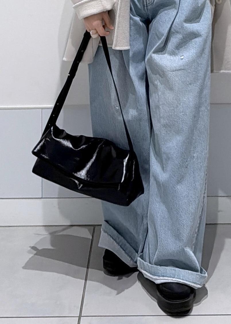 ブラック系のショルダーバッグ、ホワイト系のその他アウター、ブラック系のブーツを着用したレディースの秋コーディネートの8枚目の写真