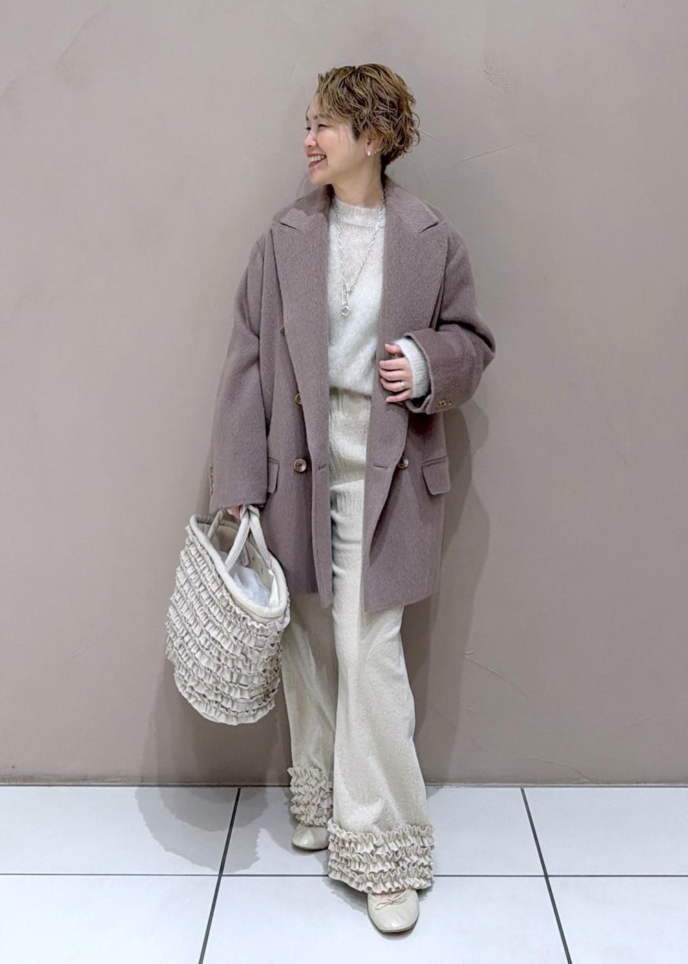 ベージュ系のパンプス、ブラウン系のチェスターコートを着用したレディースの冬コーディネートの2枚目の写真