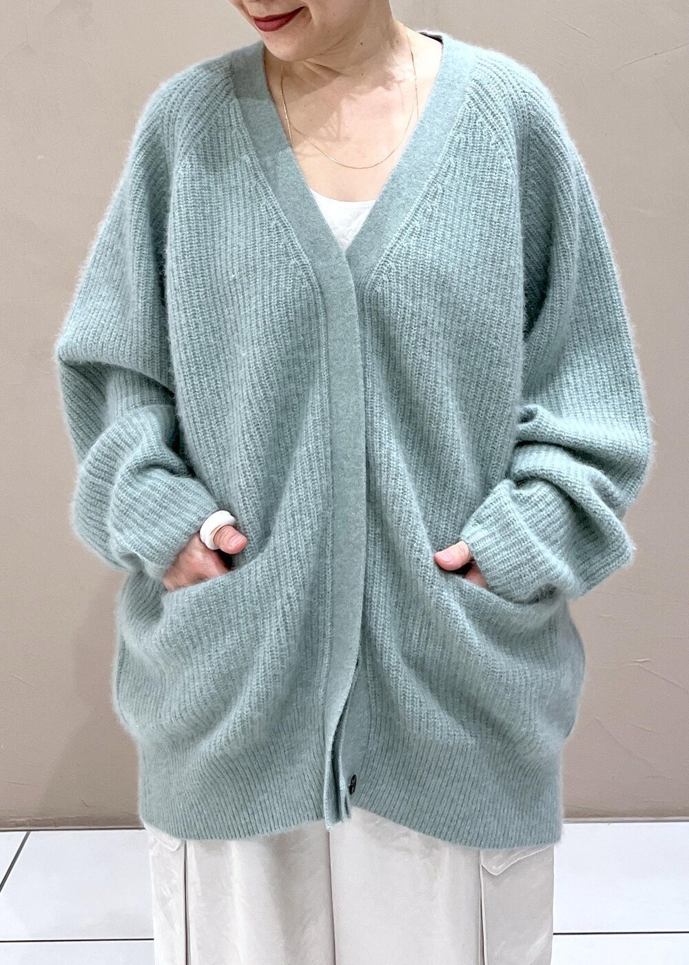 ホワイト系のTシャツ/カットソー、グリーン系のカーディガン/ボレロ、ホワイト系のカーゴパンツを着用したレディースの秋コーディネートの8枚目の写真