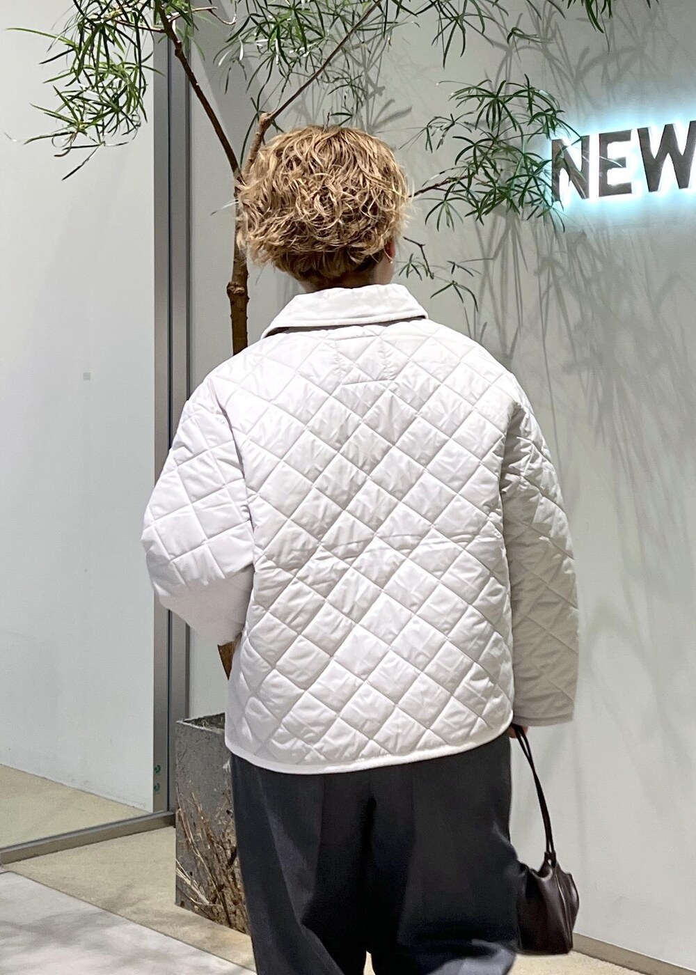 ピンク系のブルゾン、ブラウン系のハンドバッグ、ブラック系のパンプスを着用したレディースの秋コーディネートの8枚目の写真