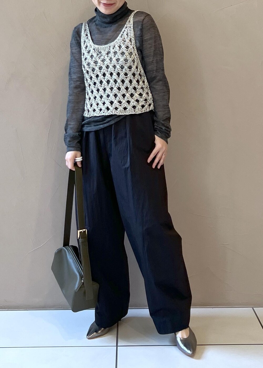 シルバー系のベスト、グレー系のニット/セーター、ブラック系のその他パンツを着用したレディースの秋コーディネートの5枚目の写真