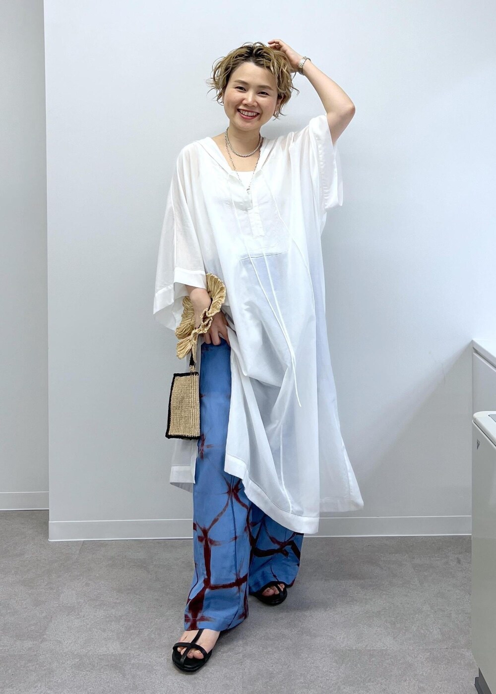 ブラック系のサンダル、ホワイト系のワンピース、ブルー系のその他パンツを着用したレディースの春コーディネートの3枚目の写真
