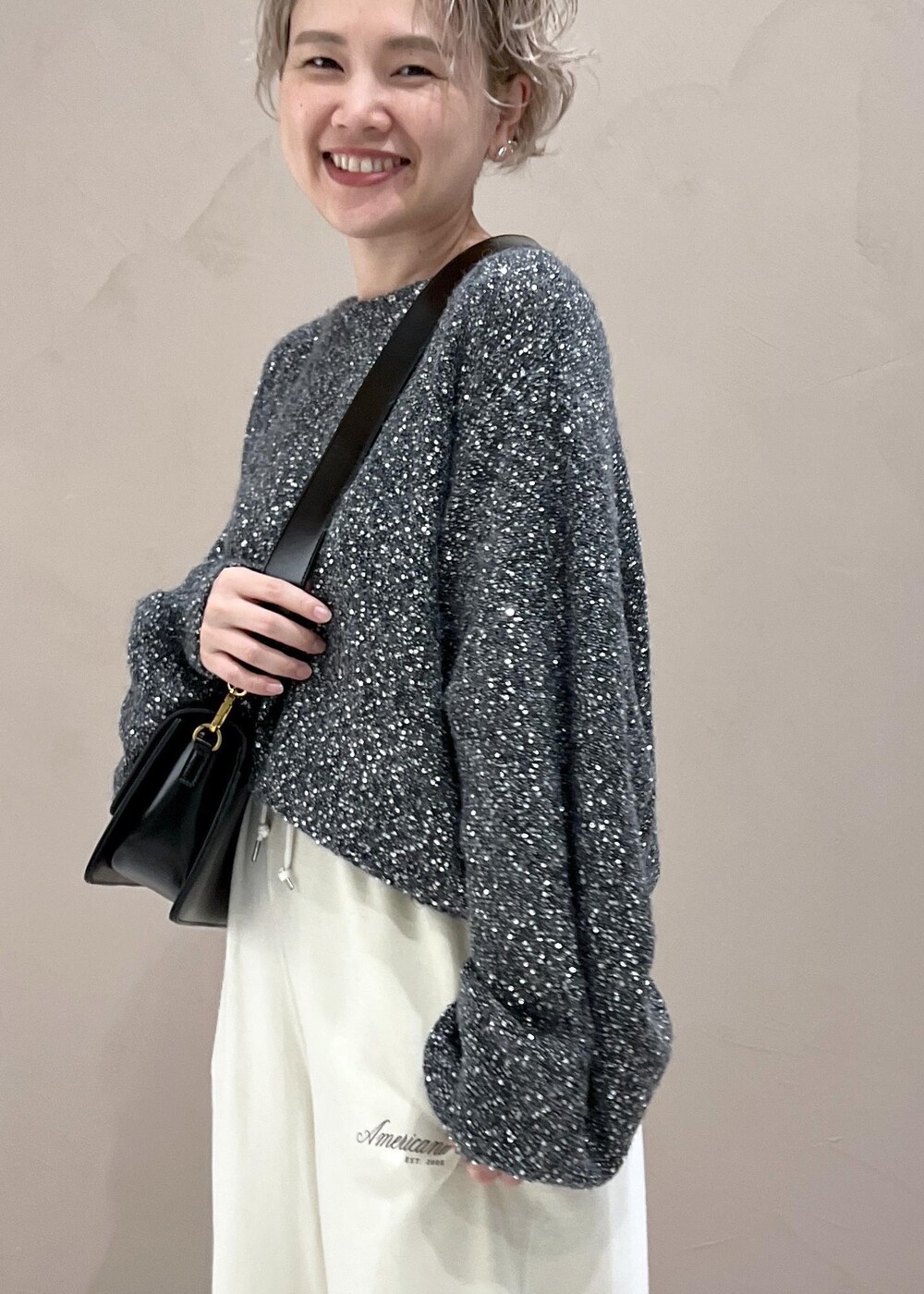 ホワイト系のスウェットパンツ、ブラック系のショルダーバッグ、シルバー系のパンプスを着用したレディースの秋コーディネートの7枚目の写真