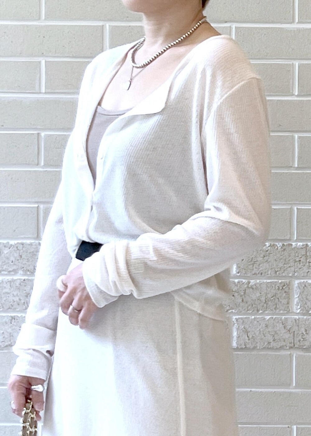 ホワイト系のスカート、ベージュ系のショルダーバッグ、ホワイト系のカーディガン/ボレロを着用したレディースの夏コーディネートの5枚目の写真