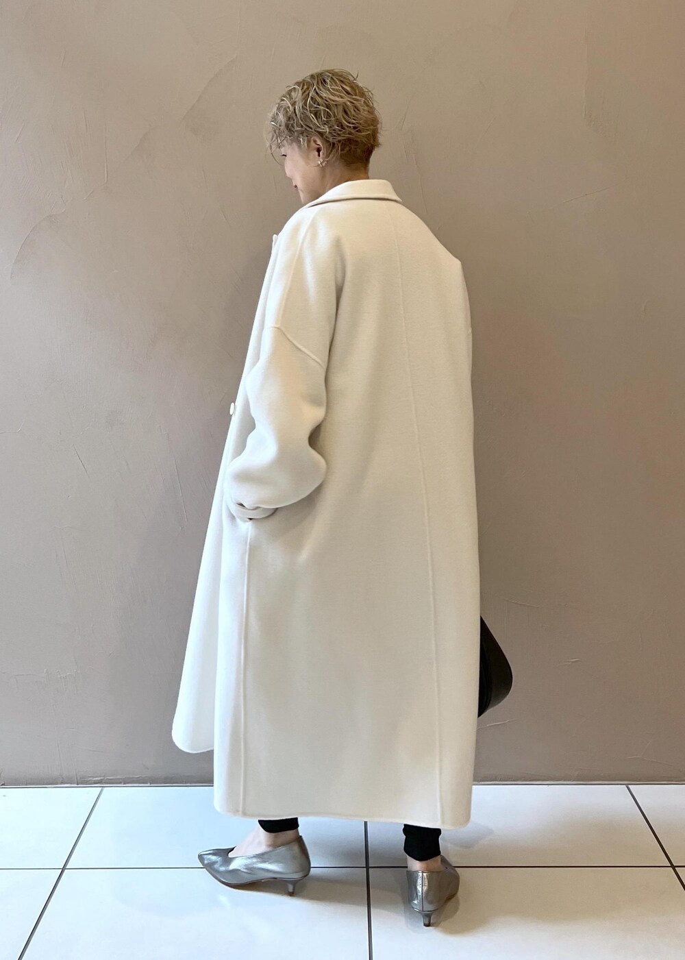 ホワイト系のその他アウター、シルバー系のパンプス、ブラック系のその他パンツを着用したレディースの秋コーディネートの5枚目の写真