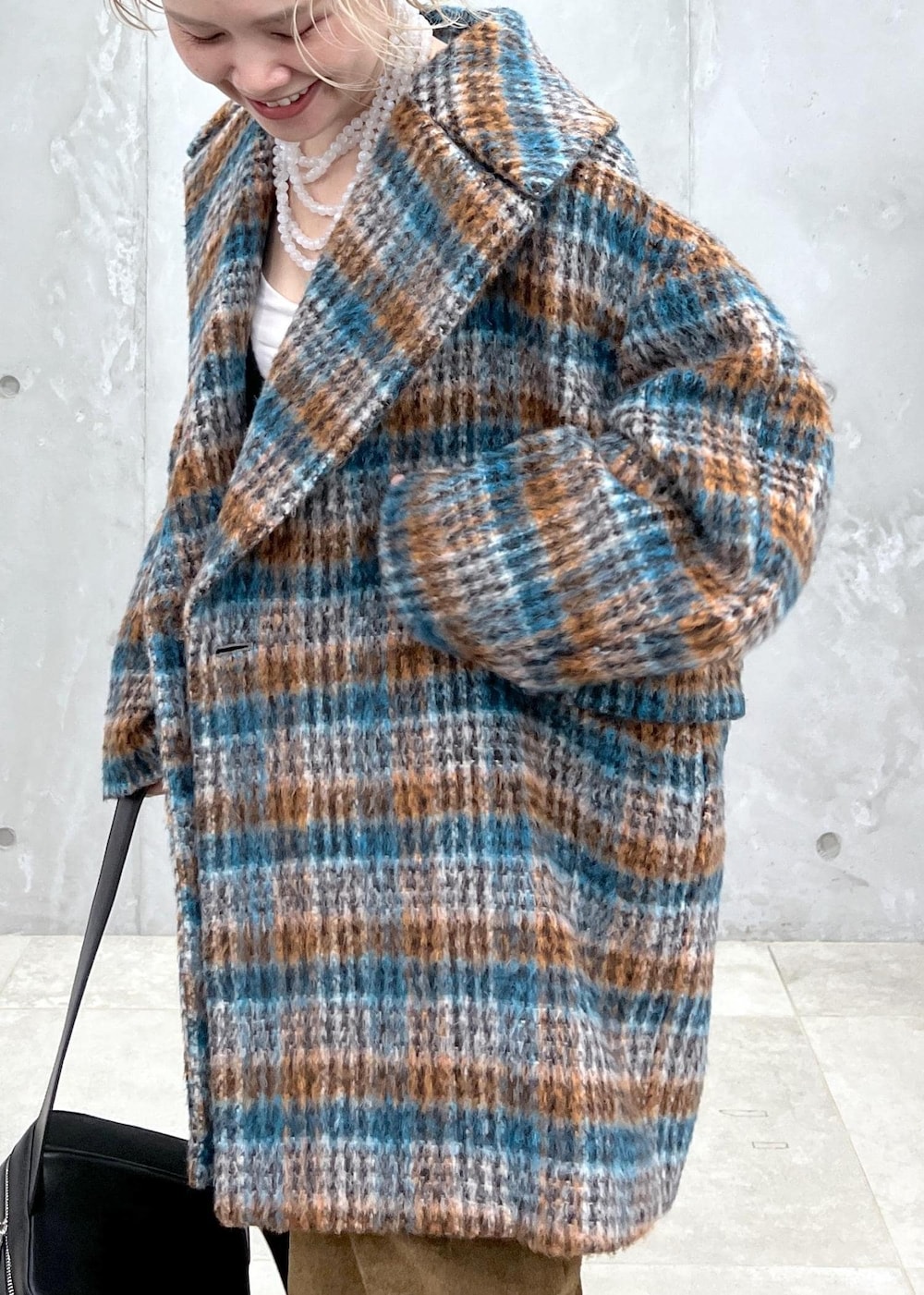 ブラック系のベスト、ブルー系のピーコート、ブラック系のボディバッグ/ウエストポーチを着用したレディースの秋コーディネートの5枚目の写真