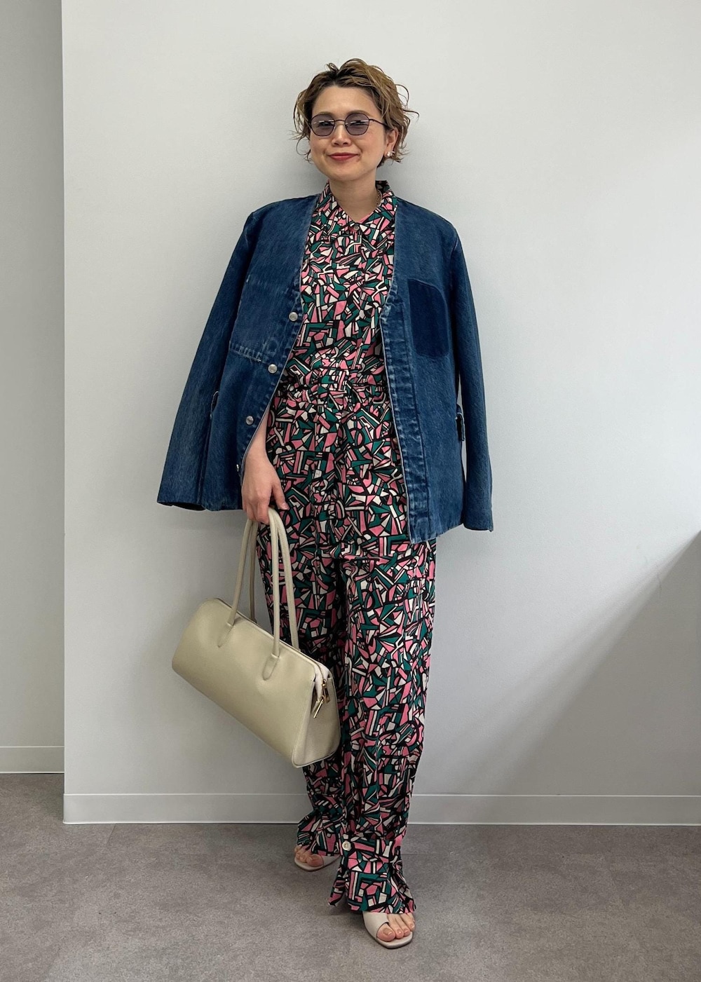 ホワイト系のボストンバッグ、グレー系のサンダル、グリーン系のつなぎ/オールインワンを着用したレディースの春コーディネートの4枚目の写真