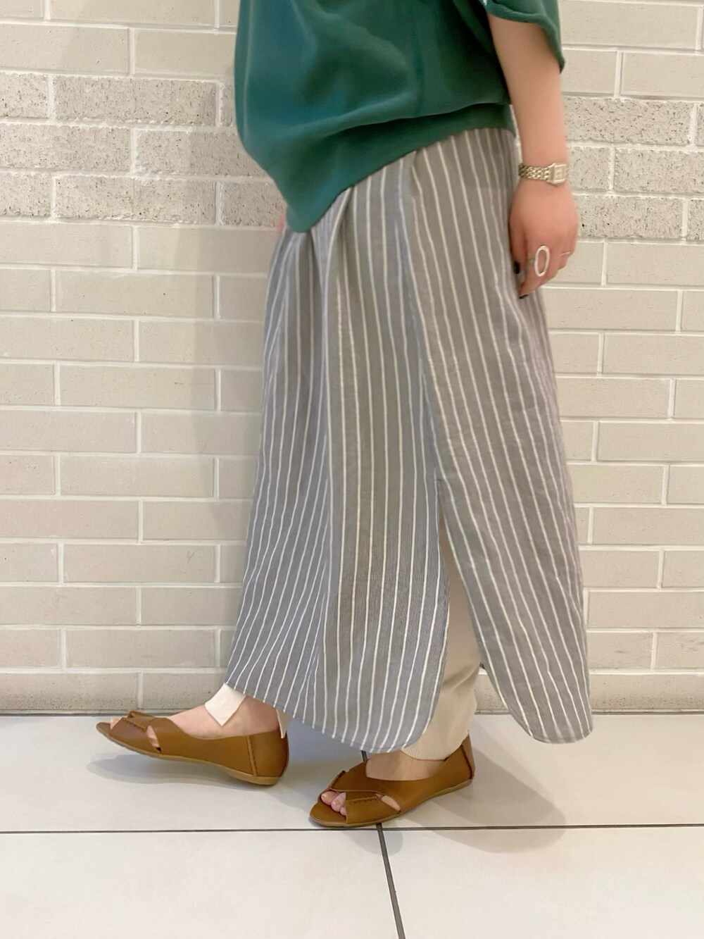 グリーン系のスウェット、ブラック系のワンピース、ブラウン系のサンダルを着用したレディースの春コーディネートの3枚目の写真