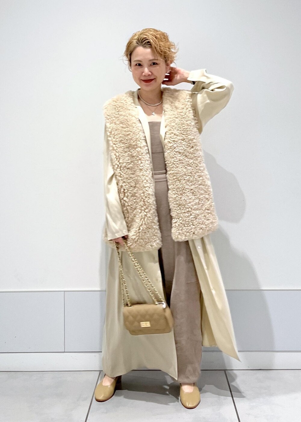 グレー系のカーゴパンツ、ベージュ系のベスト、グレー系のキャミソールを着用したレディースの秋コーディネートの2枚目の写真
