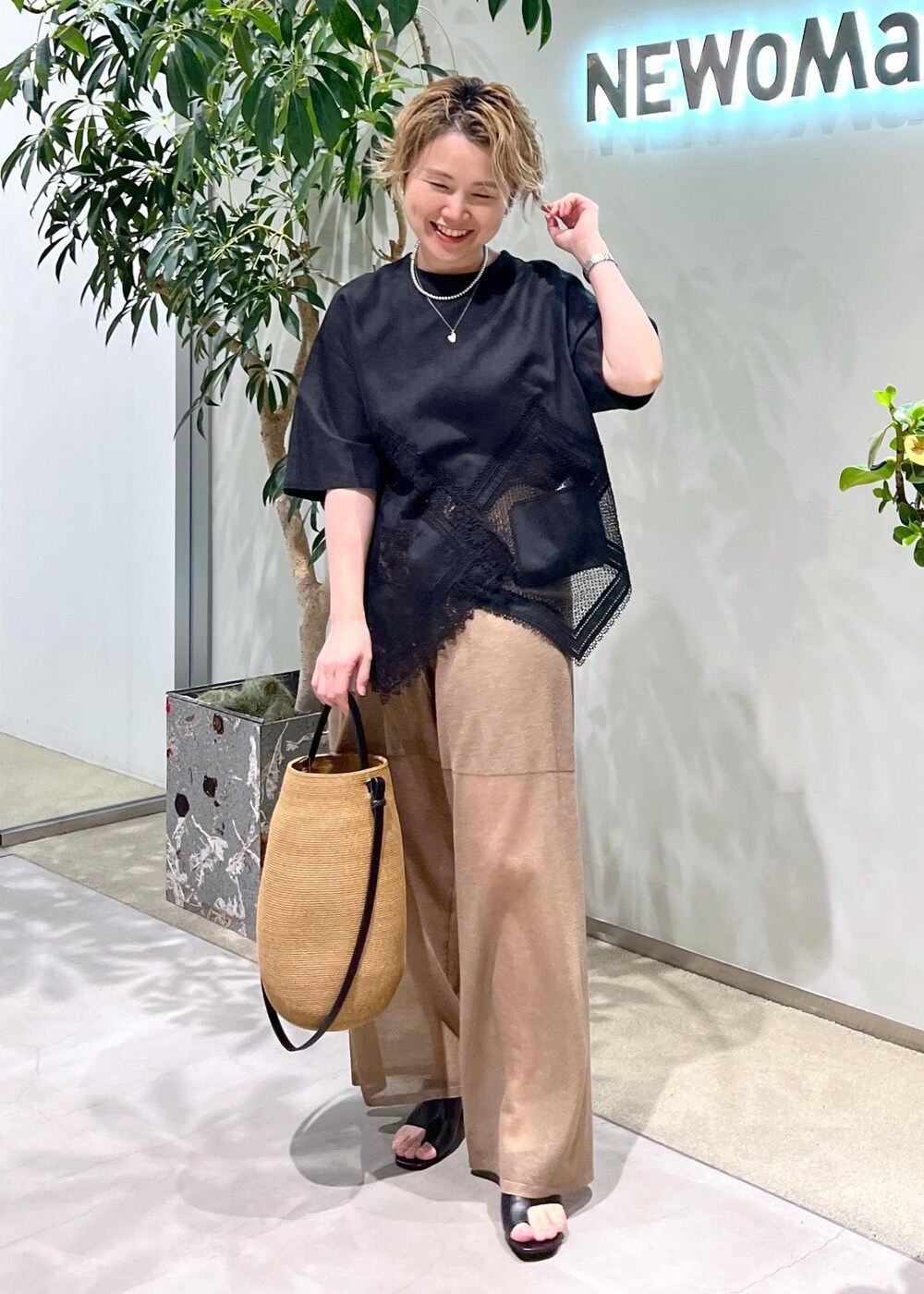 ブラック系のサンダル、ブラック系のTシャツ/カットソー、ゴールド系のその他パンツを着用したレディースの夏コーディネートの2枚目の写真