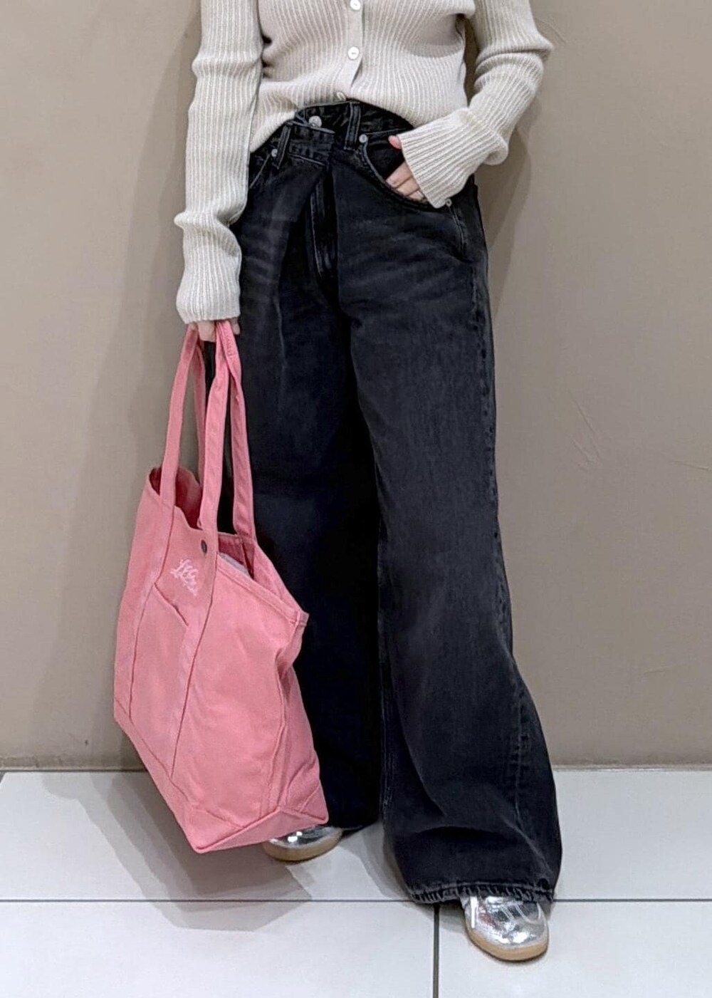 ベージュ系のカーディガン/ボレロ、ピンク系のトートバッグ、ブラック系のデニムパンツを着用したレディースの冬コーディネートの8枚目の写真