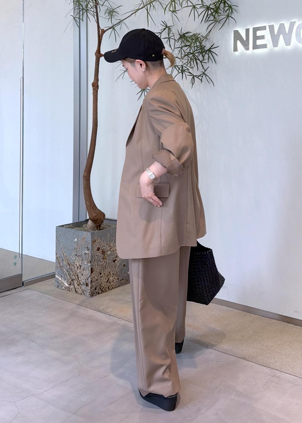 ベージュ系のその他パンツ、ベージュ系のテーラードジャケット、ブラック系のトートバッグを着用したレディースの秋コーディネートの5枚目の写真