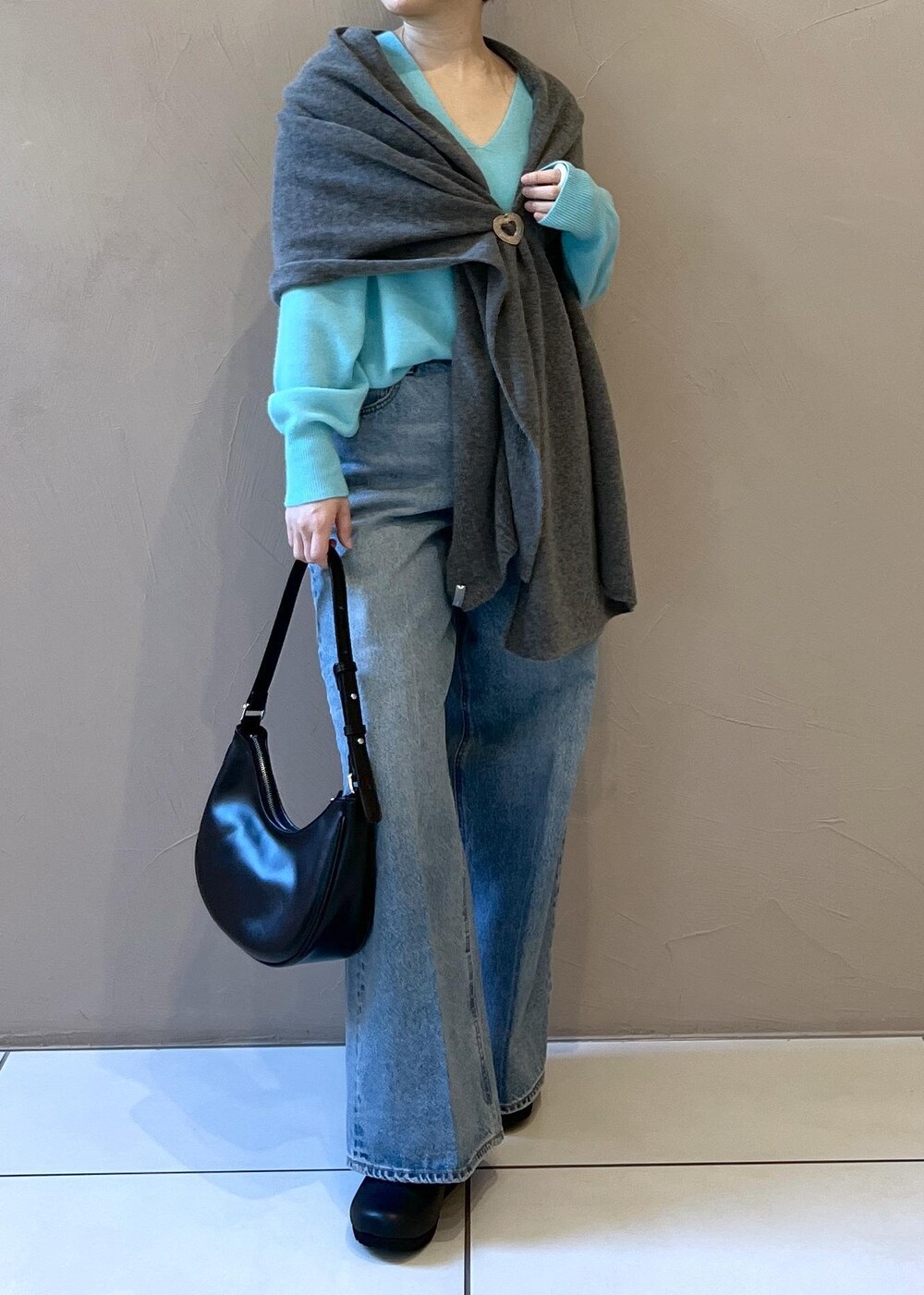 ブルー系のニット/セーター、ブルー系のデニムパンツ、ブラック系のスニーカーを着用したレディースの秋コーディネートの5枚目の写真