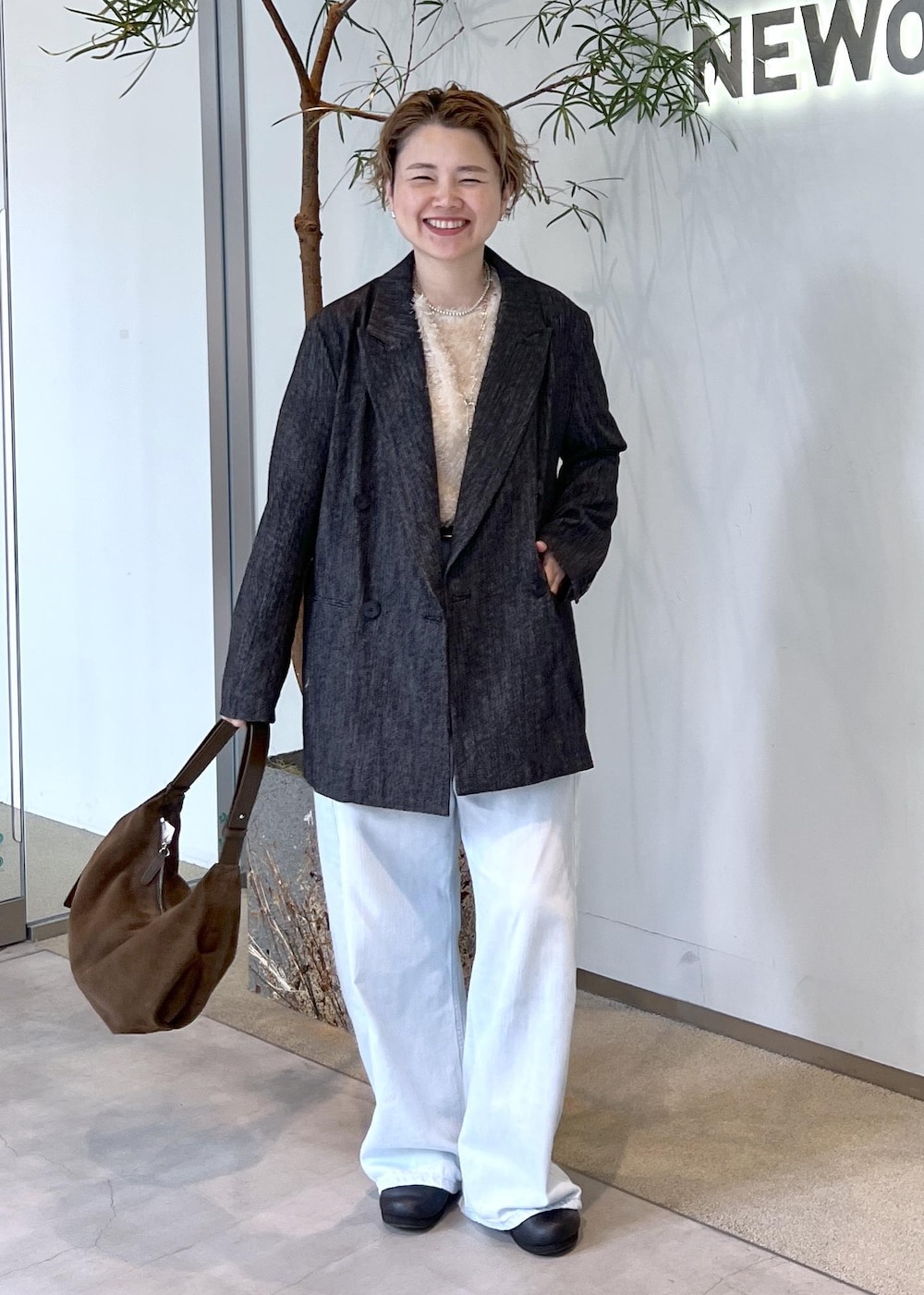 ブルー系のデニムパンツ、ベージュ系のその他トップス、ブラック系のテーラードジャケットを着用したレディースの秋コーディネートの3枚目の写真