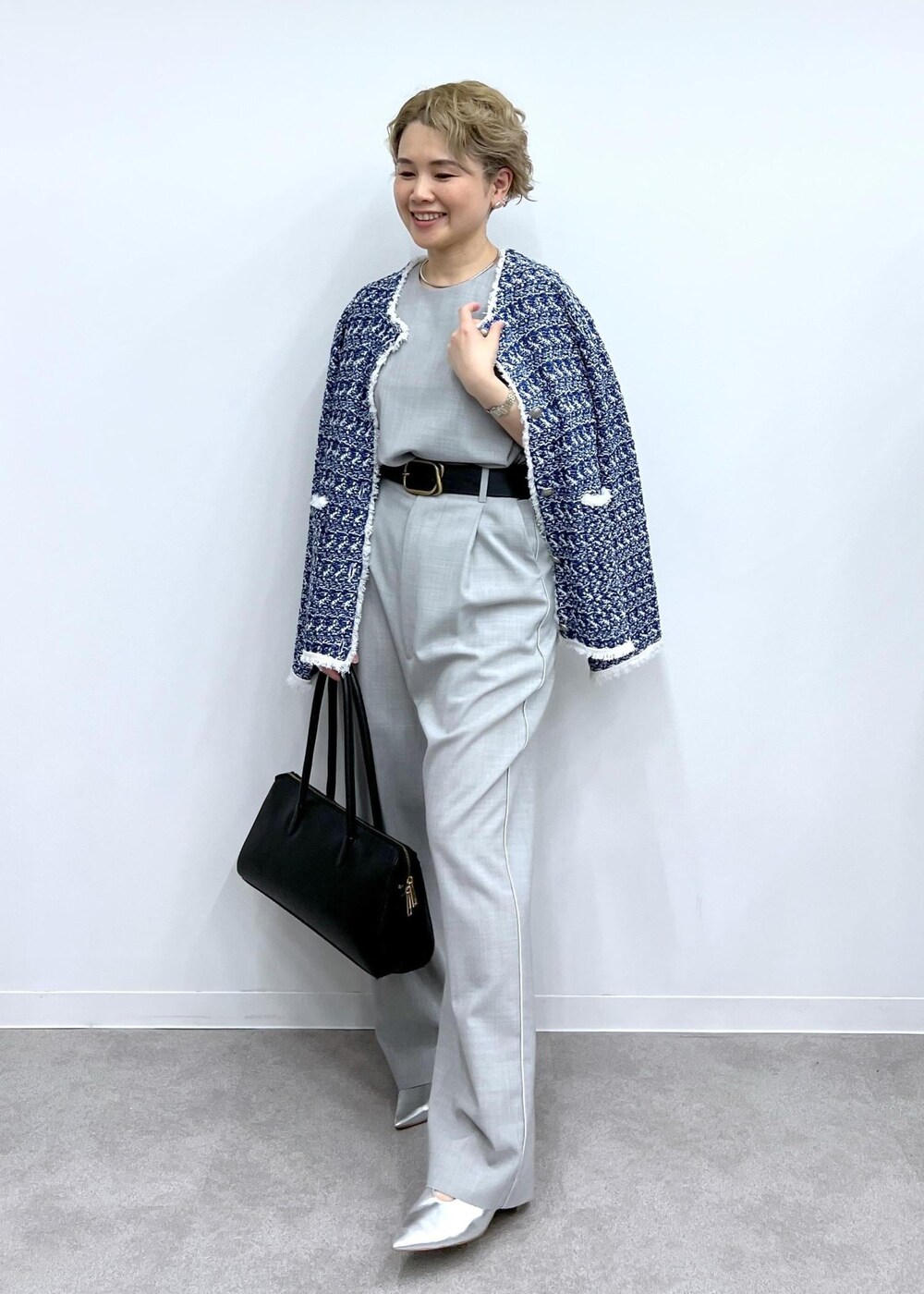 グレー系のベスト、グレー系のスラックス、シルバー系のパンプスを着用したレディースの春コーディネートの2枚目の写真