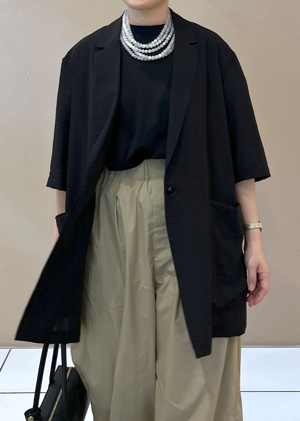 ベージュ系のその他パンツ、ブラック系のショルダーバッグ、ホワイト系のサンダルを着用したレディースの夏コーディネートの5枚目の写真