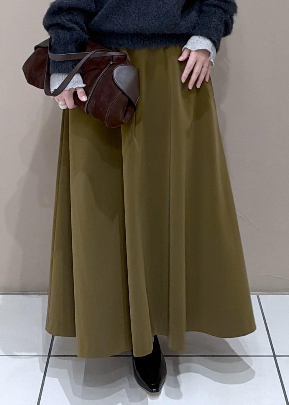 ブラウン系のスカート、ブラック系のローファー、グレー系のニット/セーターを着用したレディースの冬コーディネートの8枚目の写真