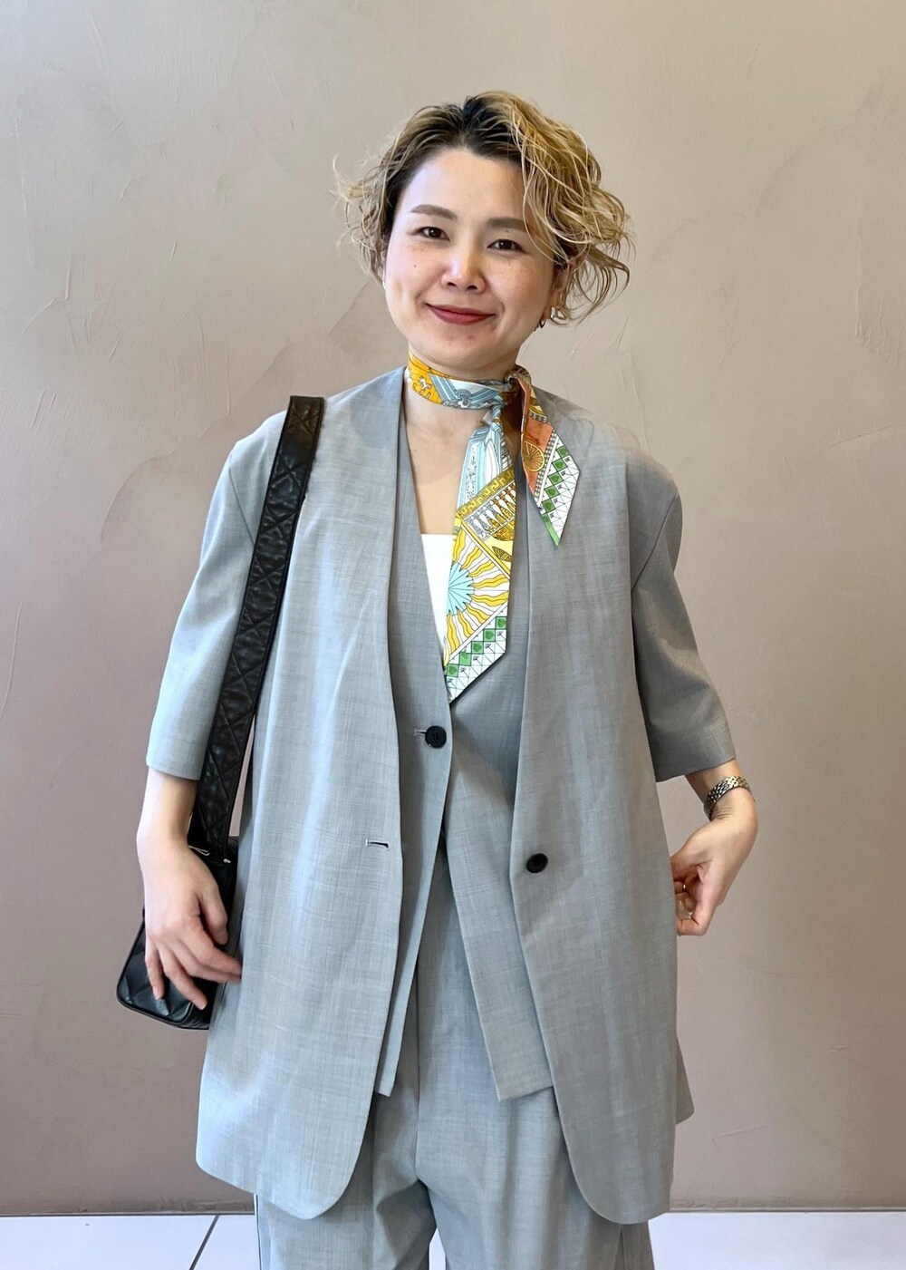 グレー系のベスト、グレー系のスラックス、グレー系のテーラードジャケットを着用したレディースの冬コーディネートの5枚目の写真