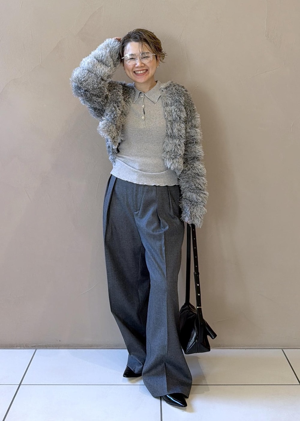 ブラック系のショルダーバッグ、グレー系のスラックス、グレー系のカーディガン/ボレロを着用したレディースの冬コーディネートの5枚目の写真