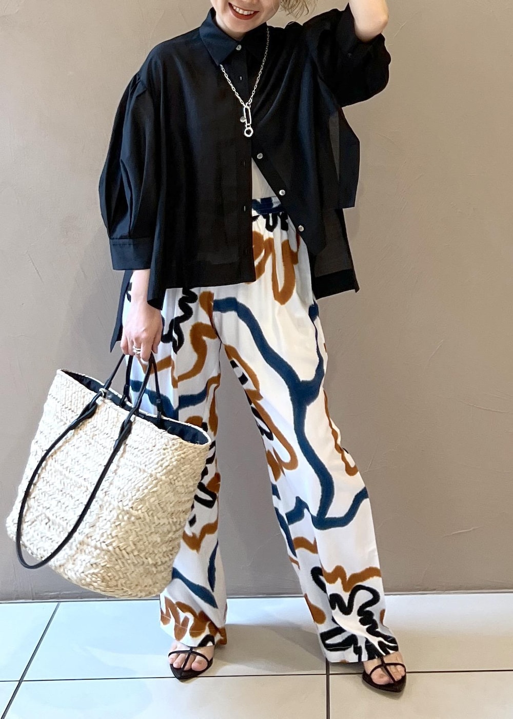 ブラック系のサンダル、ホワイト系のかごバッグ、ブラック系のシャツ/ブラウスを着用したレディースの春コーディネートの8枚目の写真