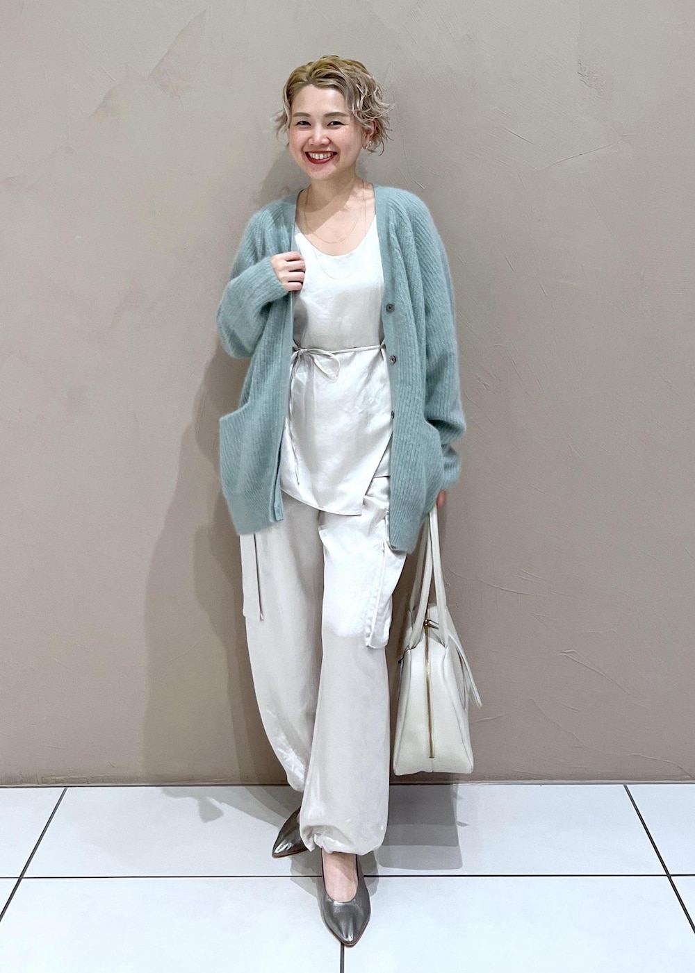ホワイト系のTシャツ/カットソー、グリーン系のカーディガン/ボレロ、ホワイト系のカーゴパンツを着用したレディースの秋コーディネートの3枚目の写真