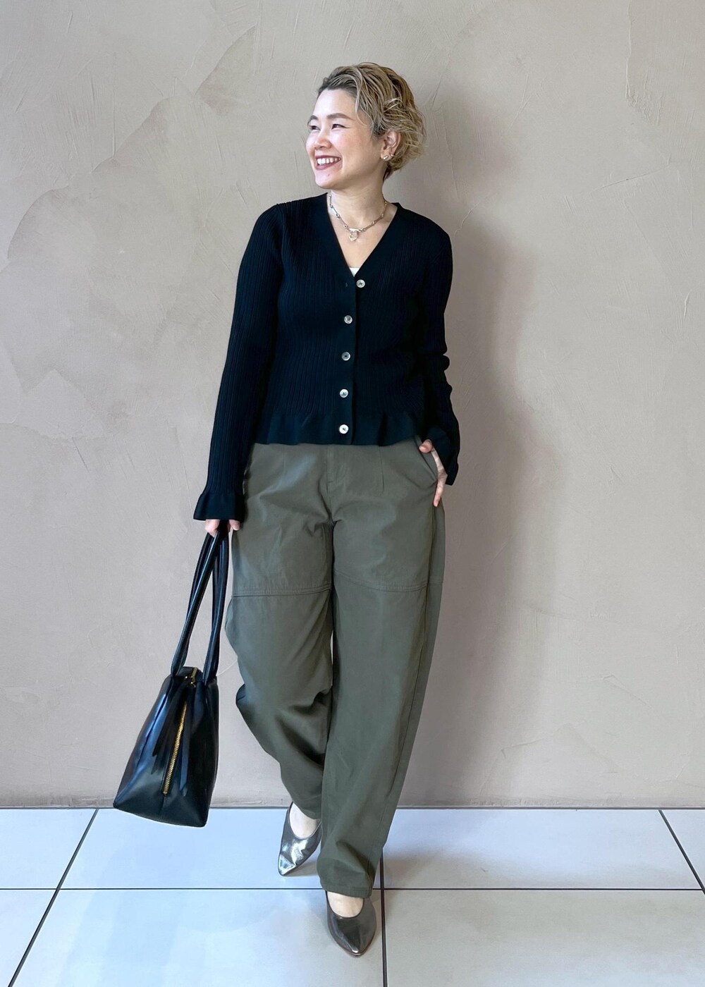 ブラック系のカーディガン/ボレロ、グリーン系のその他パンツ、ブラック系のボストンバッグを着用したレディースの冬コーディネートの2枚目の写真