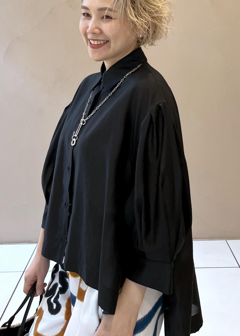 ブラック系のサンダル、ホワイト系のかごバッグ、ブラック系のシャツ/ブラウスを着用したレディースの春コーディネートの6枚目の写真