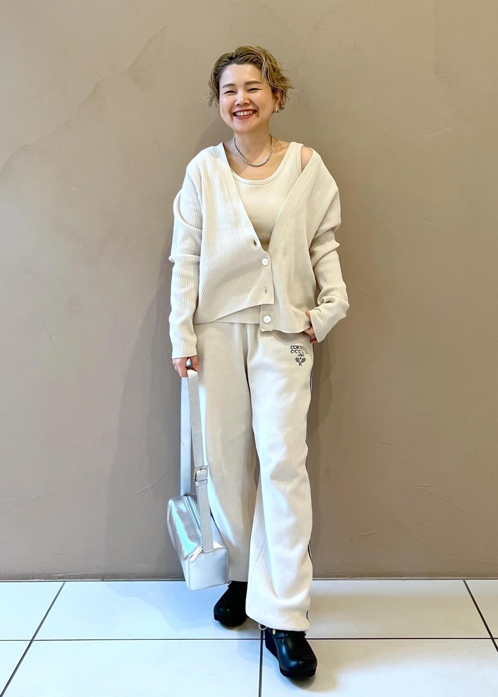 シルバー系のショルダーバッグ、ホワイト系のカーディガン/ボレロ、ホワイト系のその他パンツを着用したレディースの冬コーディネートの2枚目の写真