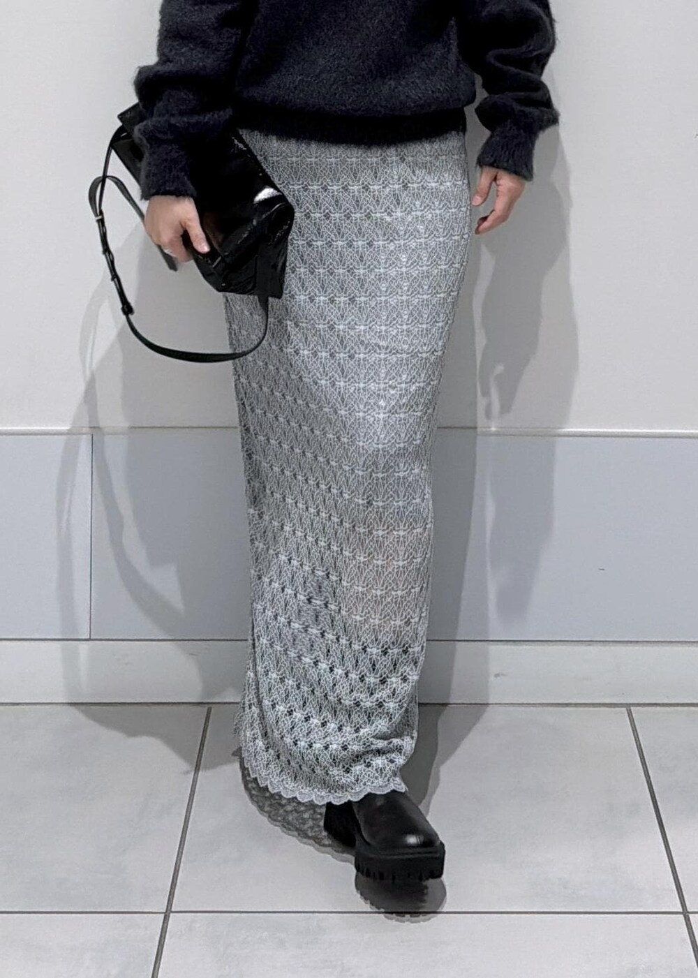 ブラック系のショルダーバッグ、グリーン系のスカート、ブラック系のブーツを着用したレディースの秋コーディネートの6枚目の写真