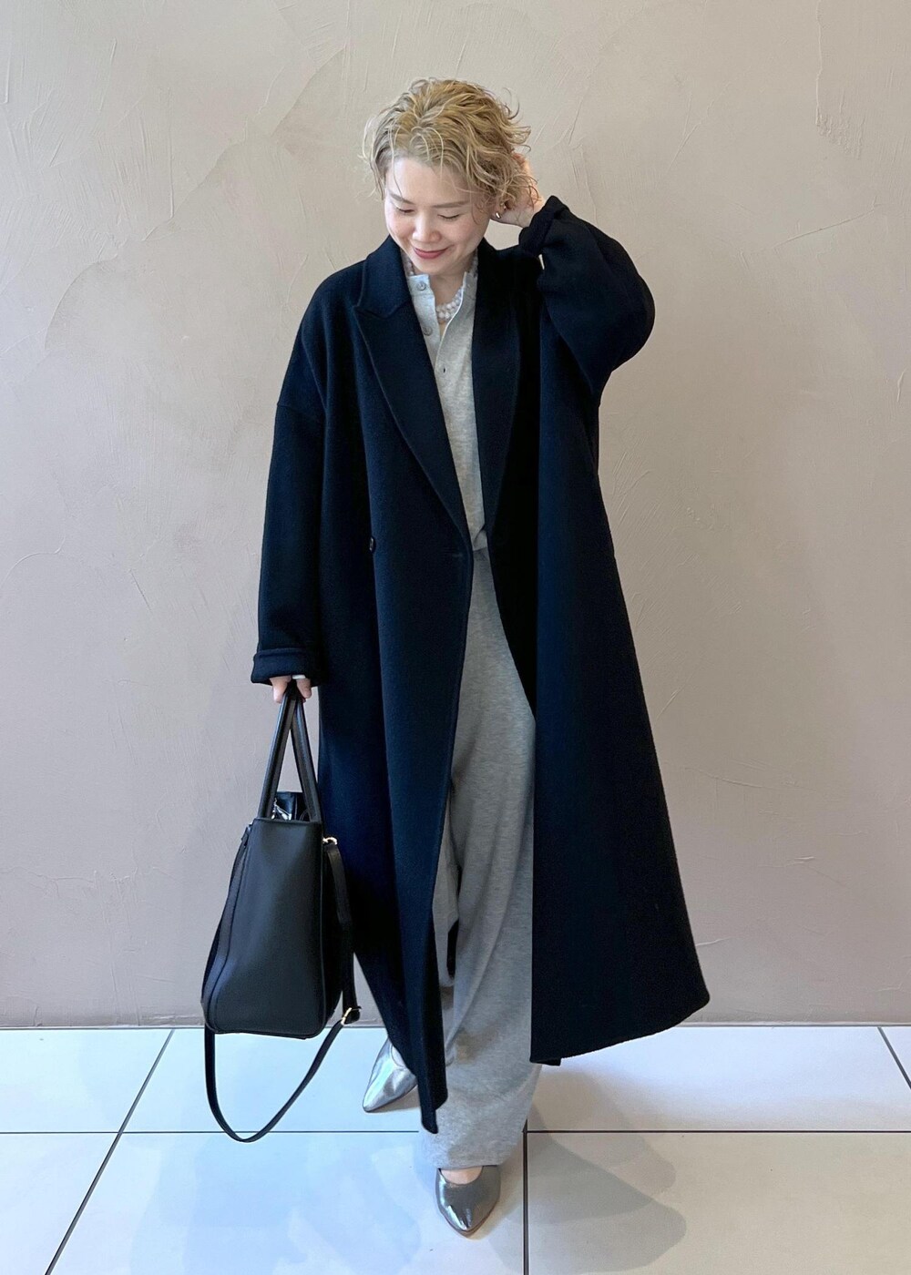 ブラック系のハンドバッグ、ブラック系のその他アウター、シルバー系のパンプスを着用したレディースの秋コーディネートの3枚目の写真